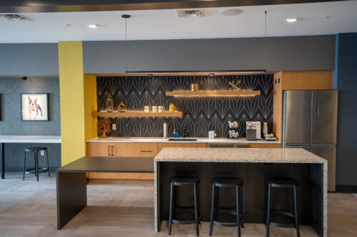 Kitchen with seating bar, fridge, sink, and coffee maker at the resident clubhouse.